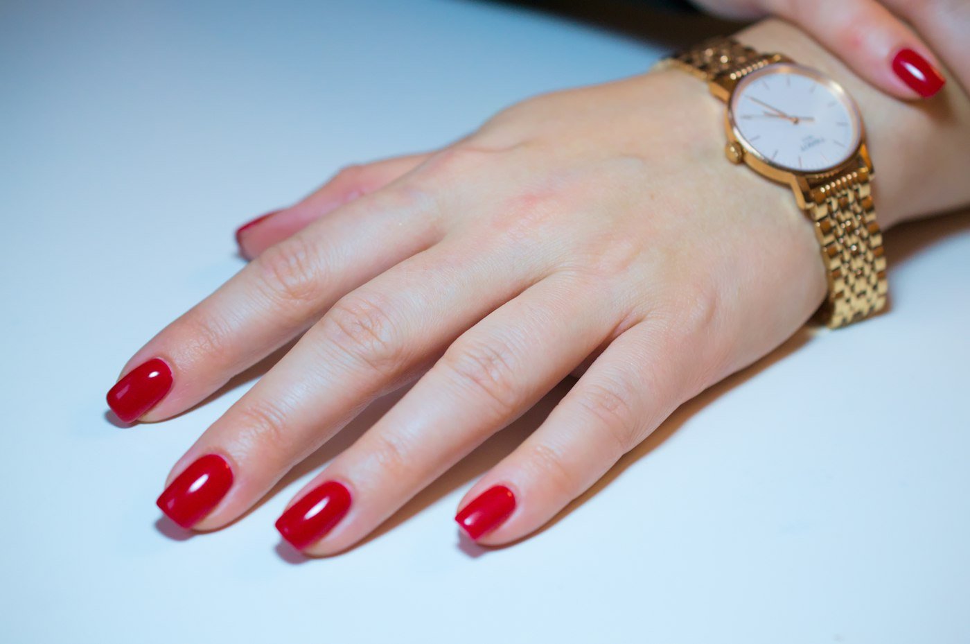Neat manicured hand with a gold watch