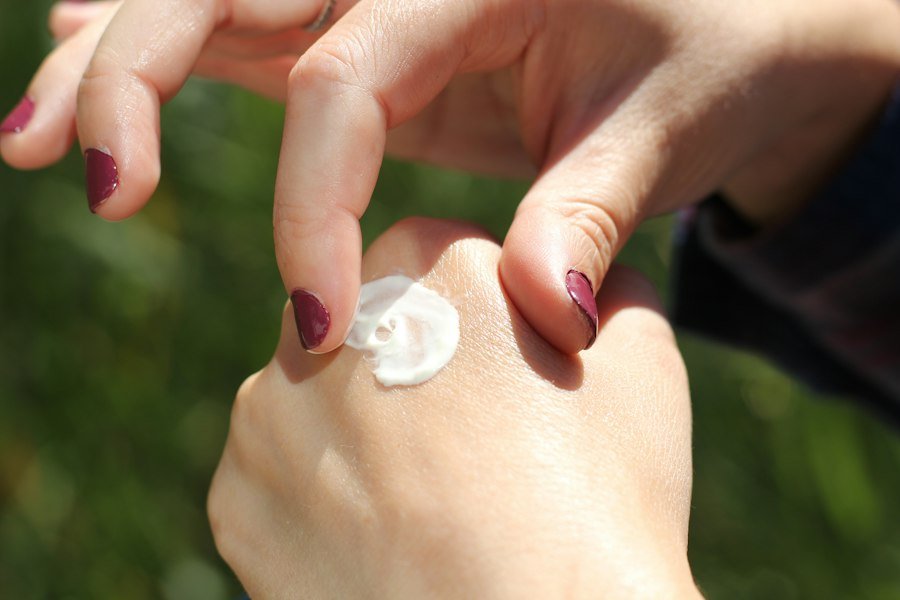 Hand cream being smoothed onto manicured hands