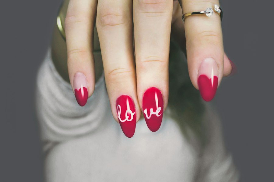 Pink nail art with a red love design