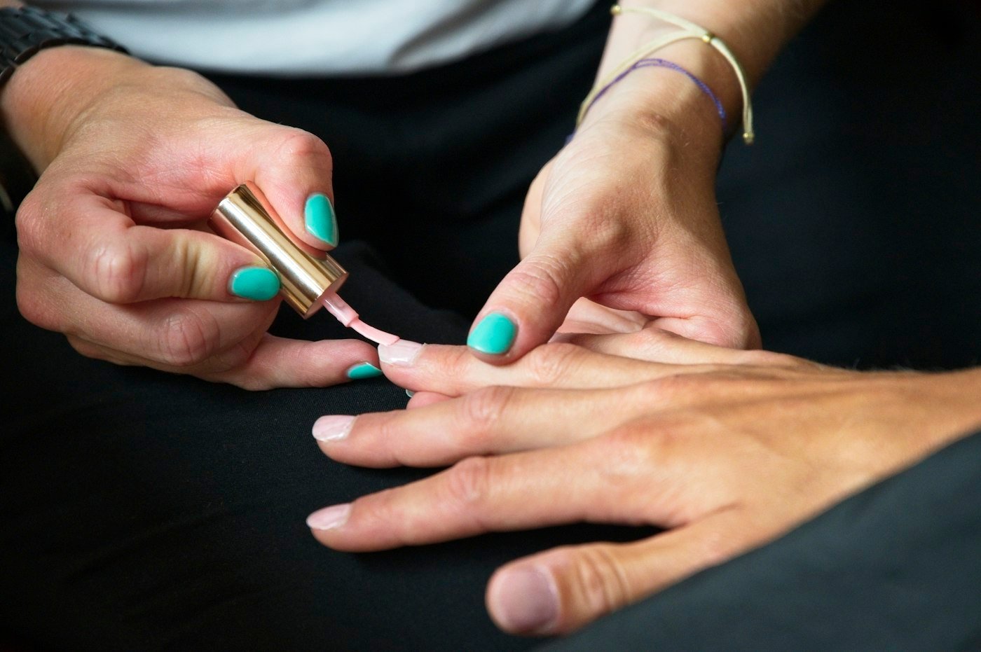 Nail technician painting a client's nails