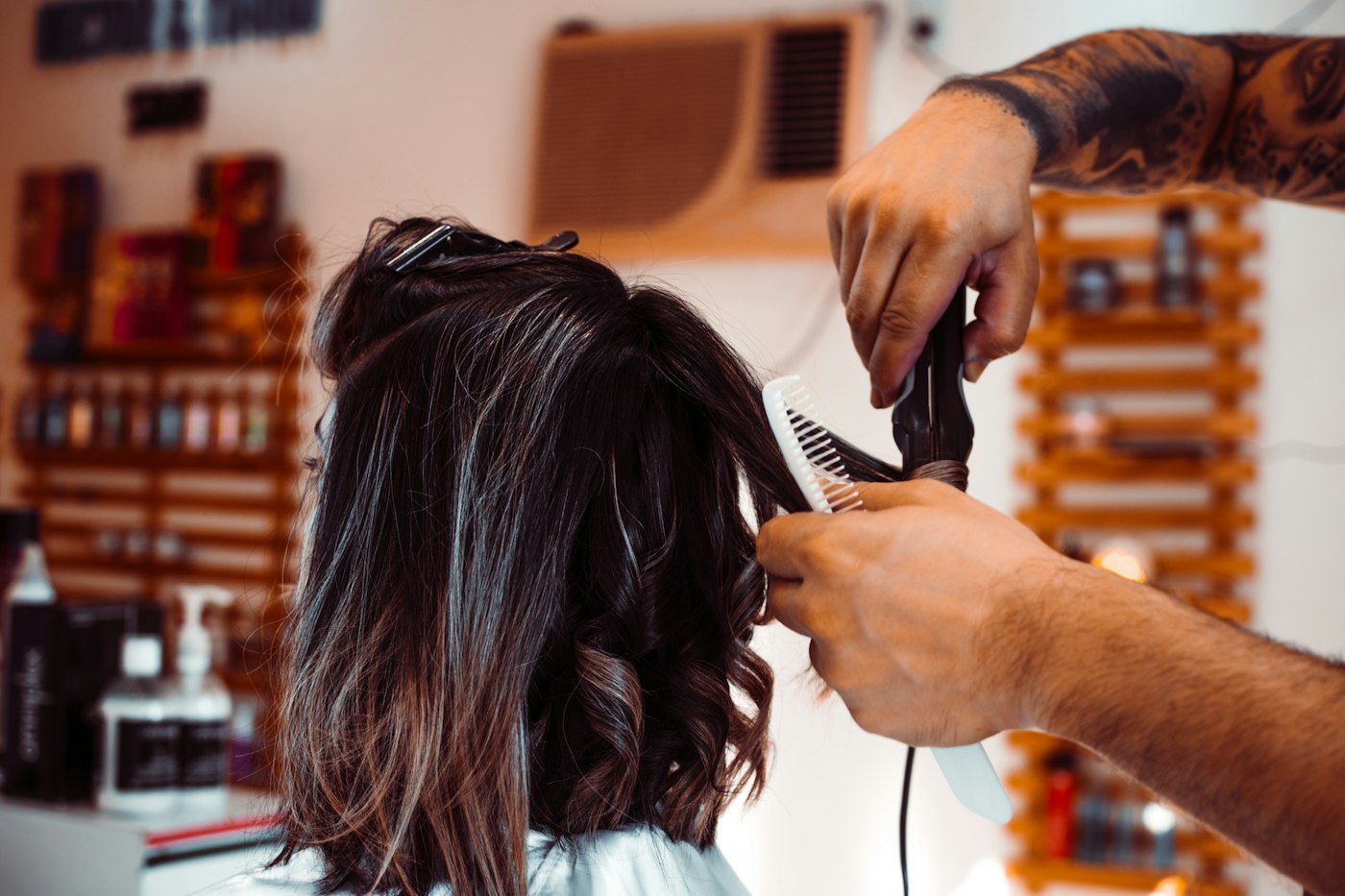 Stylist blow drying a client's hair in the salon