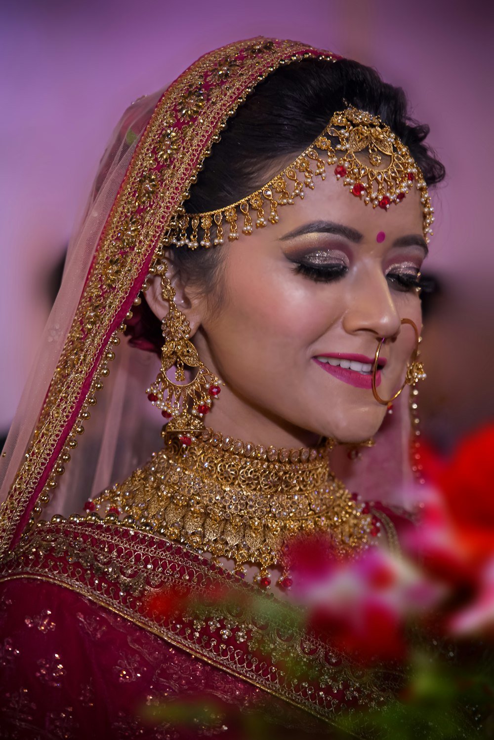 Bride in red with a veil and gold jewellery