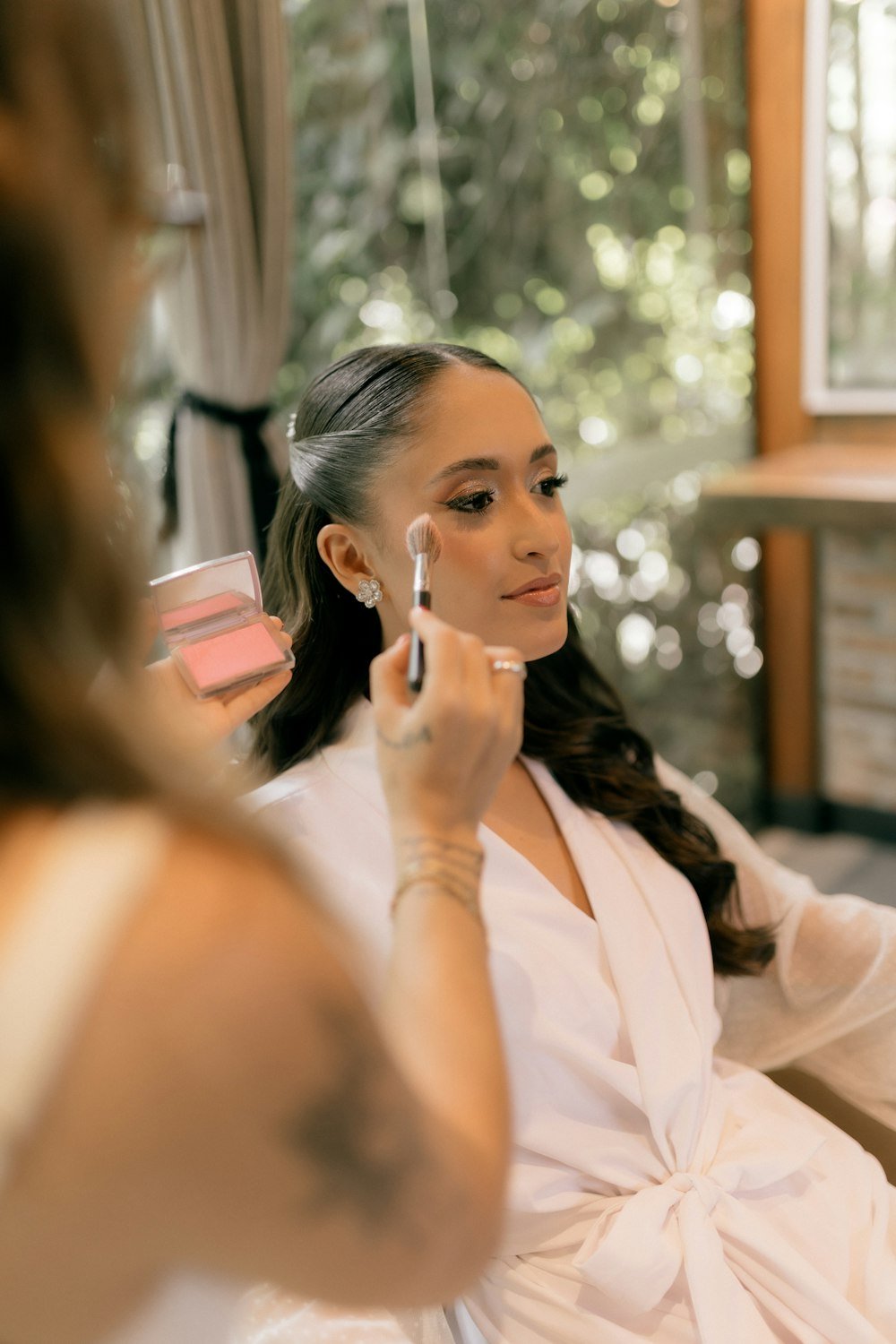 Makeup artist applying blush to a client