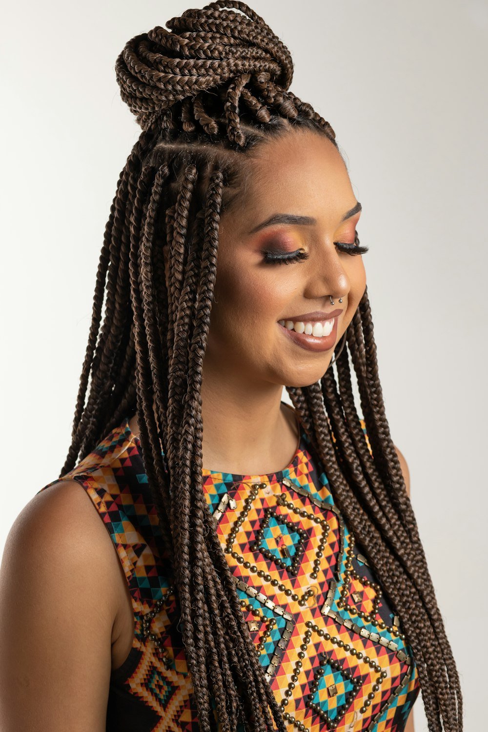 Woman with long box braids in a patterned top