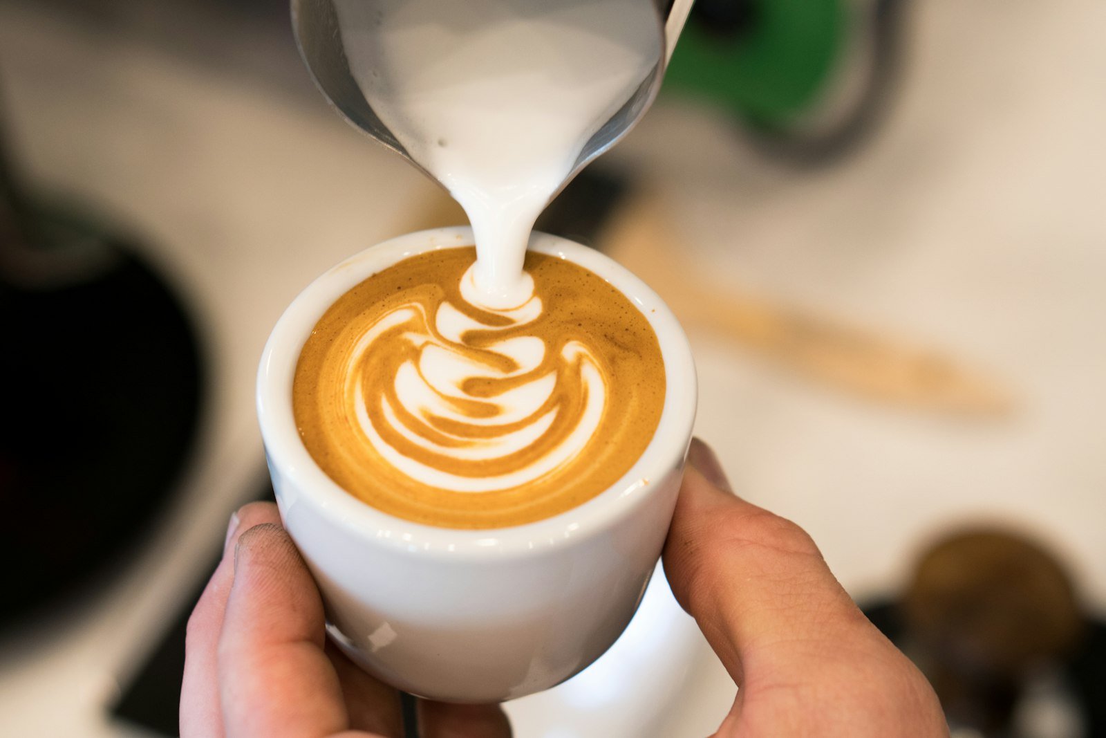 Latte art being poured into a cup