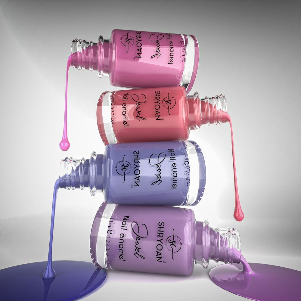 Stacked polish bottles with dripping colour