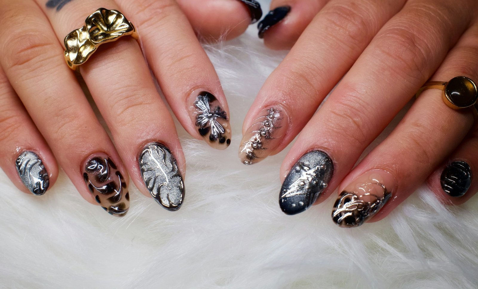 Hands with decorative leopard print and leaf nail art on soft fur