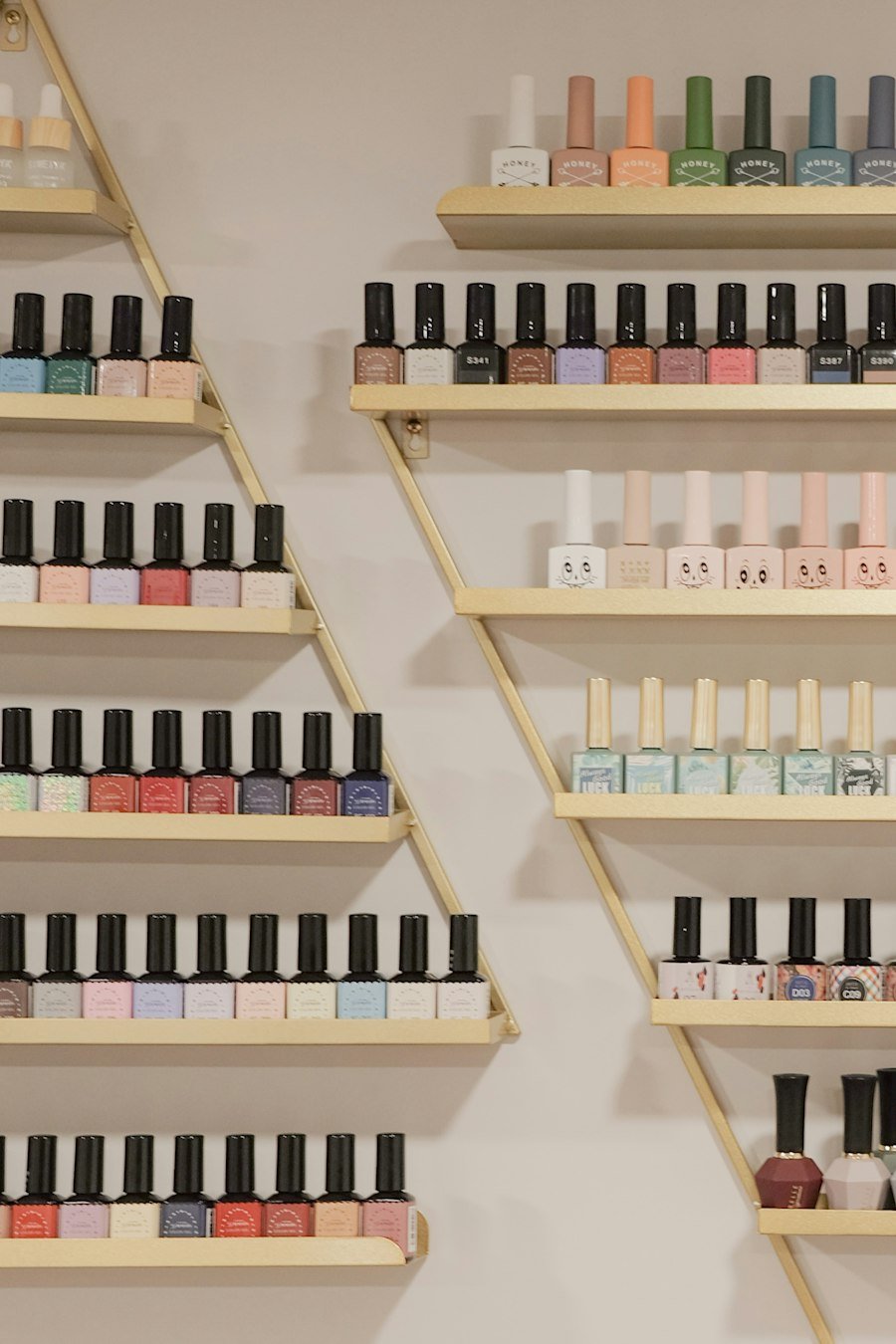 Wall of colourful nail polish bottles on gold shelves
