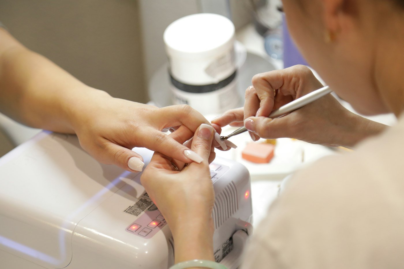 Nail technician carefully working on a manicure